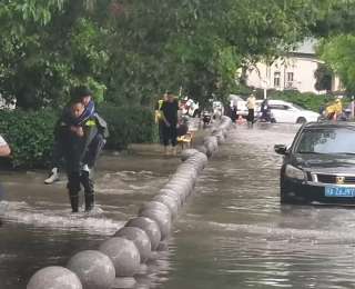 车辆熄火两名学生被困积水中，武汉执法队员背着他们蹚过渍水区
