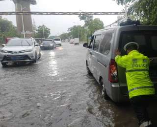面包车路过积水路段熄火，巡逻辅警迅速推车施救