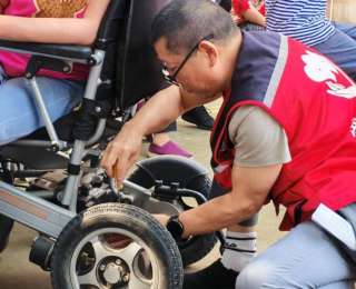 公益助残主题活动上，志愿者帮居民修轮椅