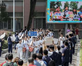 学弟学妹们手持盛放的向日葵，将400份“一举夺魁”美好祝愿送给高三考生