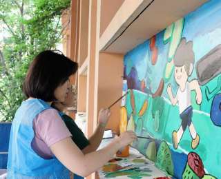 大学生顶着烈日为社区墙面“穿”上运动装