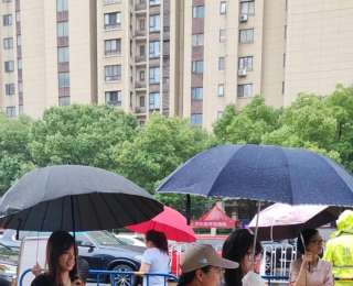 高考考点外暖心一幕：武汉志愿者撑伞护航，托举考生“无忧赴考路”